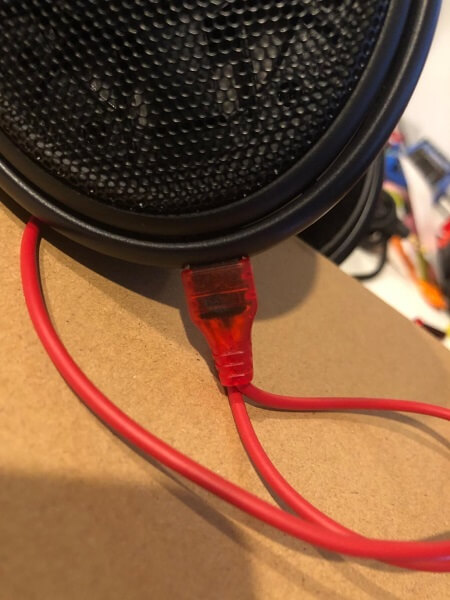 A replacement audio cable plugged into a pair of headphones