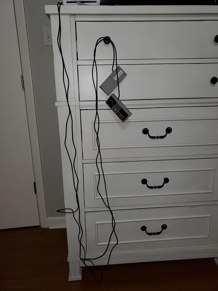 A cable going from the top of a dresser to the bottom, then back up