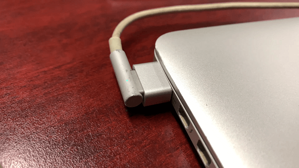 A cable with a MagSafe converter plugged into a MacBook