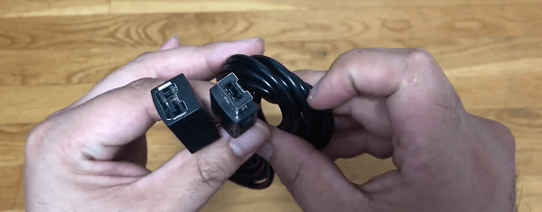 Somebody holding a coiled cable so you can see both connectors 