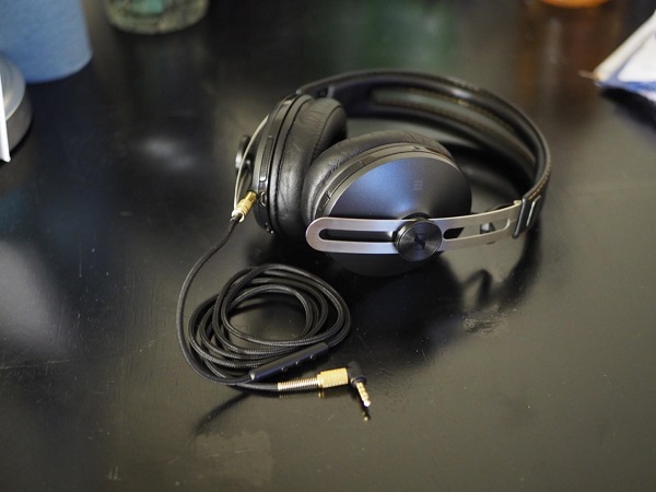 A coiled cable with one end plugged into a pair of headphones