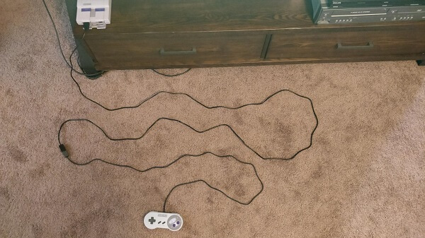 A cable connected to both the NES and the controller, and strung over the floor so you can see how long it is