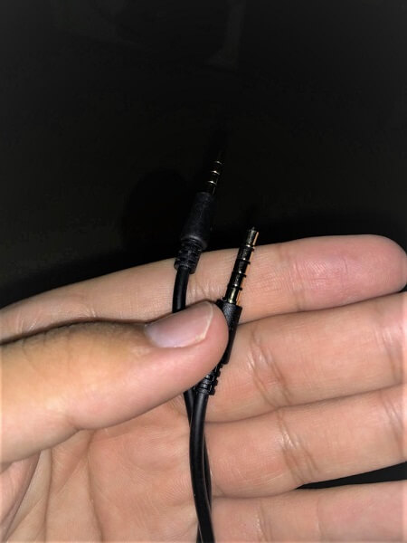 Somebody holding both ends of an audio cable