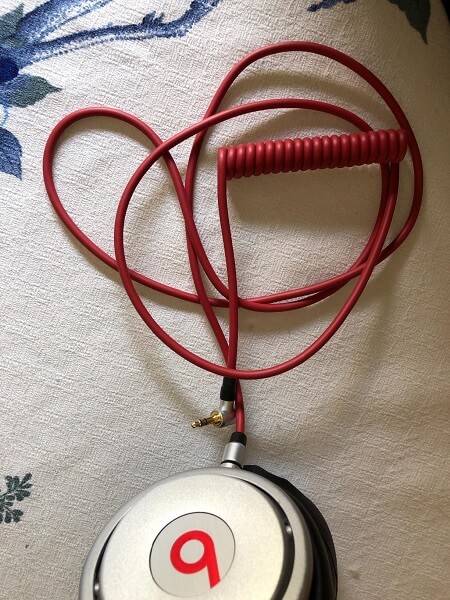 An audio cable plugged into a pair of Beats headphones