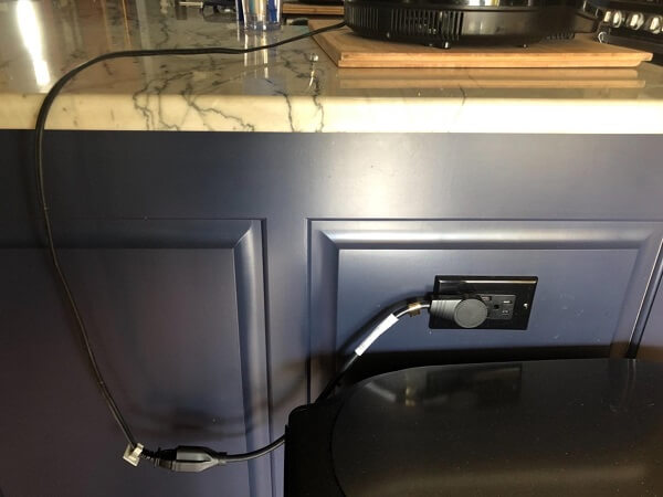A cable plugged and stretched across a kitchen island