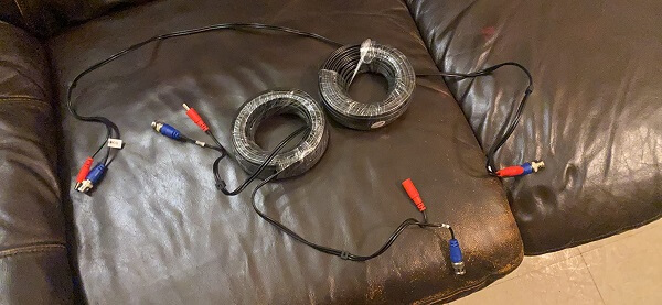 Two still partially packed extension cables on a couch