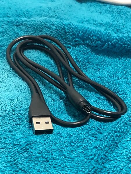 A charging cable on a blue towel