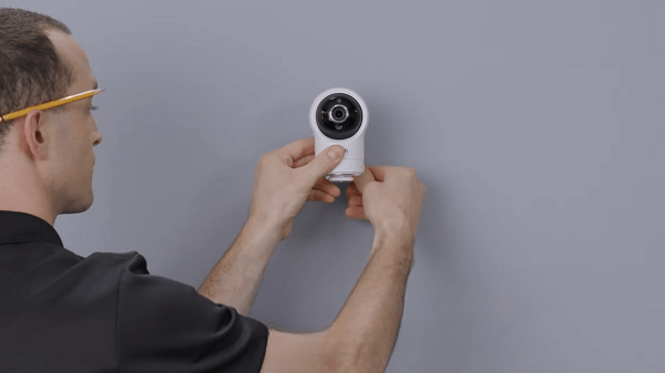 Somebody setting a baby monitor on a wall