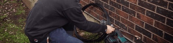 Pushing a cable through a hole in a brick wall